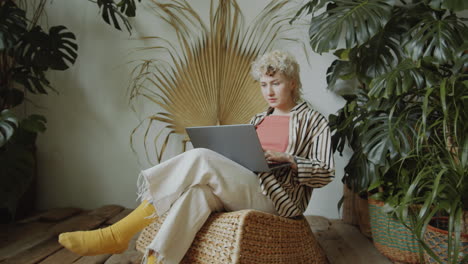 Girl-Working-on-Laptop-in-Room-with-Green-Houseplants